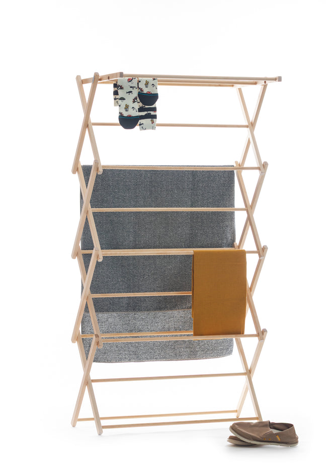 Wooden drying rack with clothes on a white background
